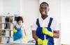 Portrait Of A Happy Male Janitor With Cleaning Equipment In Office